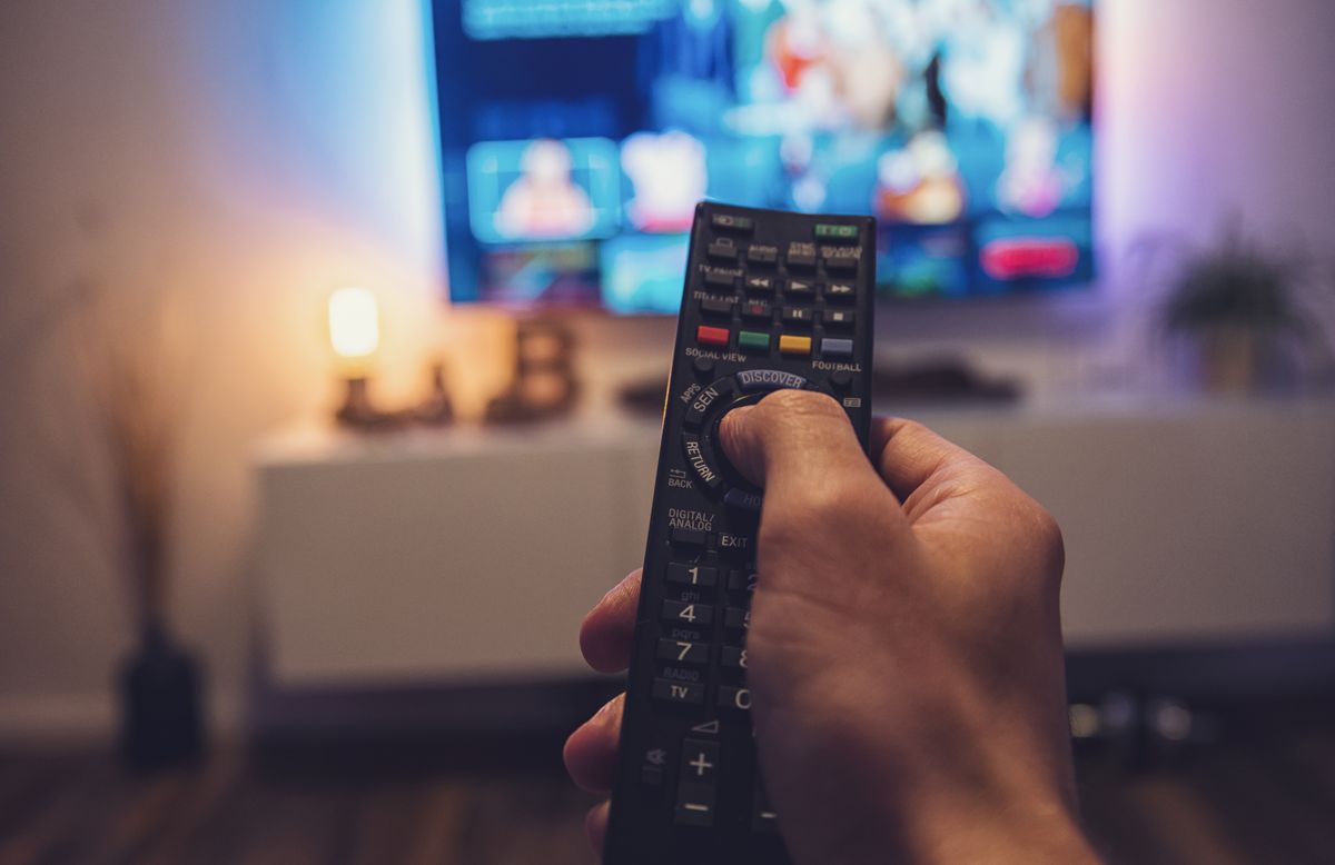 Male,Hand,Holding,Tv,Remote,Control.,Point,Of,View,Shot