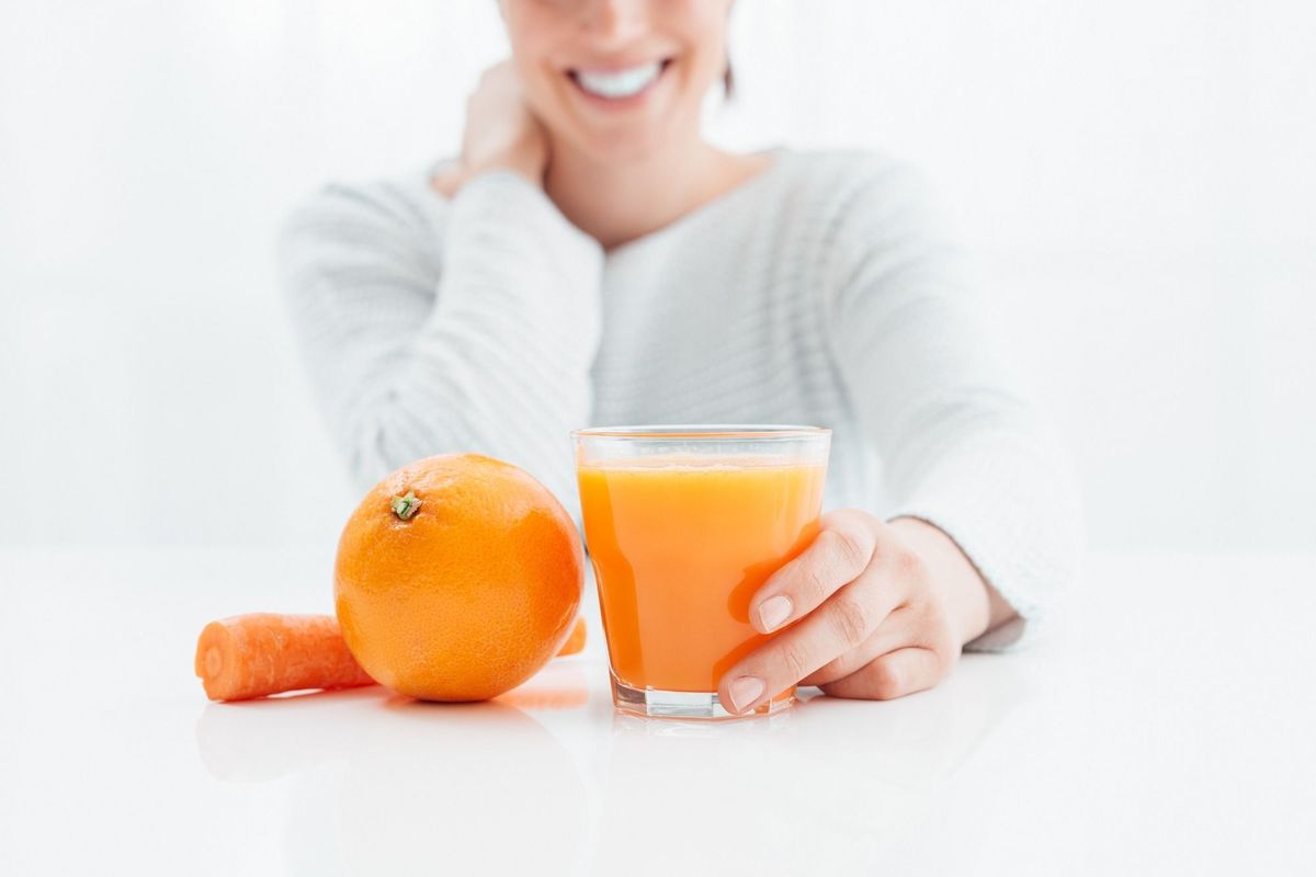 Smiling,Woman,Drinking,An,Healthy,Natural,Juice,Made,With,Oranges