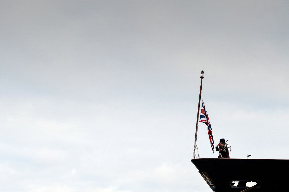 Pipe Major Steven Dewar plays a lament on the deck of the Royal Yacht Britannia in Leith, Edinburgh to mark the funeral of Queen Elizabeth II on September 19, 2022. - Leaders from around the world will attend the state funeral of Queen Elizabeth II. The country's longest-serving monarch, who died aged 96 after 70 years on the throne, will be honoured with a state funeral on Monday morning at Westminster Abbey. (Photo by Andy Buchanan / AFP)