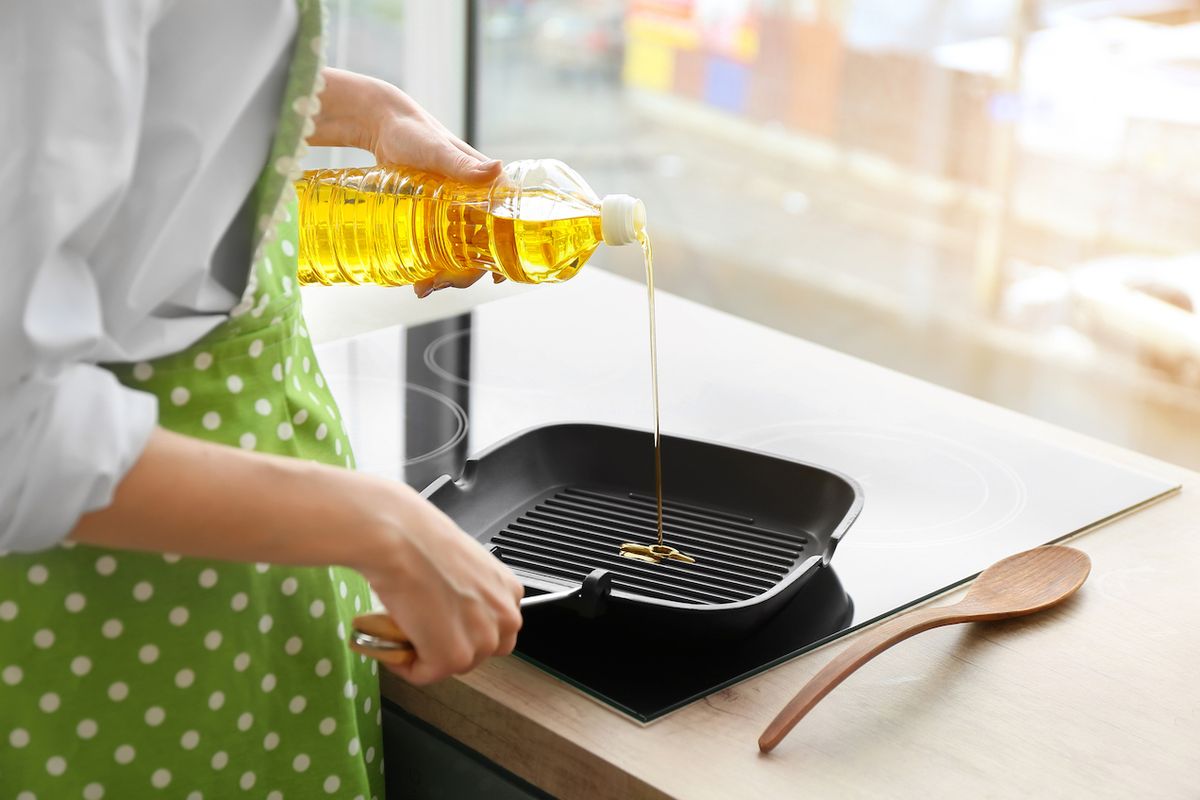 Woman,Pouring,Sunflower,Oil,Onto,Frying,Pan,In,Kitchen
2014927400