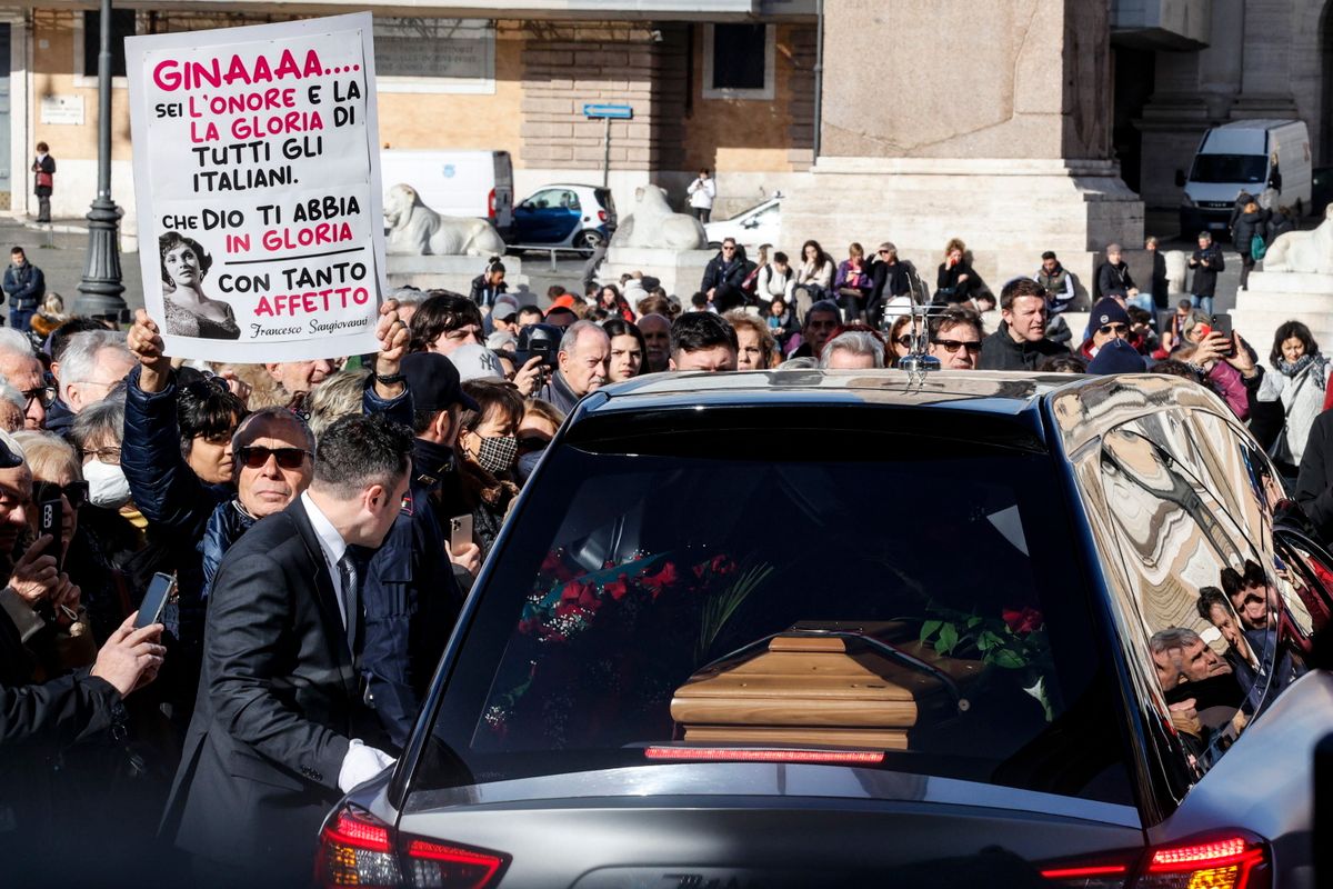 A néhai olasz színésznõ koporsóját szállító halottaskocsit állják körül Gina Lollobrigida tisztelõi a Montesantói Szűz Mária-templomban tartott gyászmise után Rómában 2023. január 19-én. 
