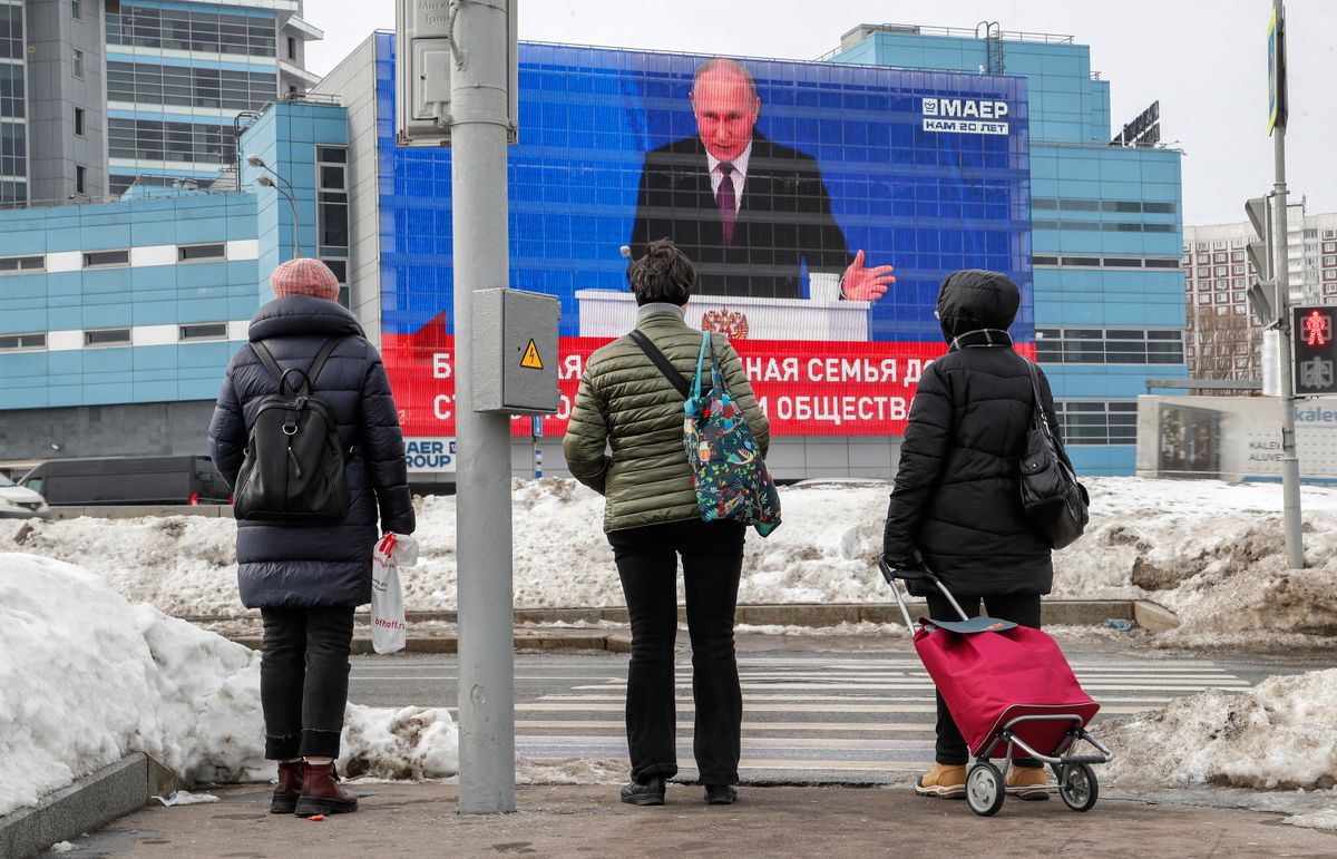 Járókelők nézik Vlagyimir Putyin évértékelő beszédét