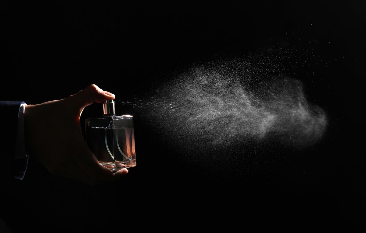 Man,Spraying,Luxury,Perfume,On,Black,Background,,Closeup