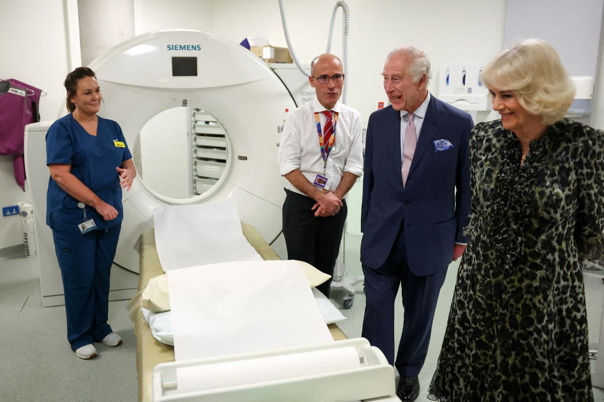 Britain's King Charles III (2R) speaks with Cancer Research UK's Chief Clinician Charlie Swanton next to a CT scanner during a visit to the University College Hospital Macmillan Cancer Centre in London on April 30, 2024. Charles is making his first official public appearance since being diagnosed with cancer, after doctors said they were "very encouraged" by the progress of his treatment. (Photo by Suzanne Plunkett / POOL / AFP)