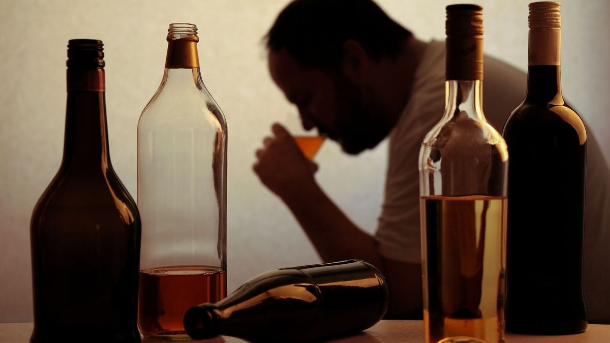 Silhouette,Of,Anonymous,Alcoholic,Person,Drinking,Behind,Bottles,Of,Alcohol