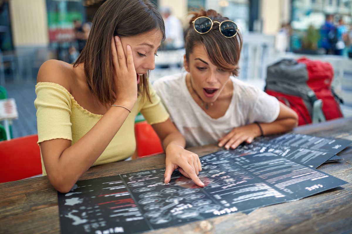 Two,Friends,Ordering,In,A,Cafe,Together,From,Menu