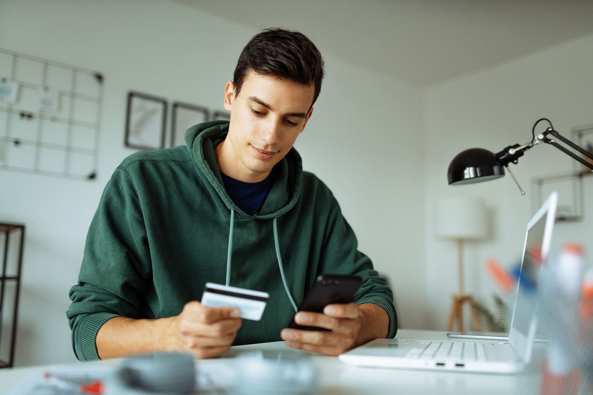 Man using credit card and mobile phone to make payment