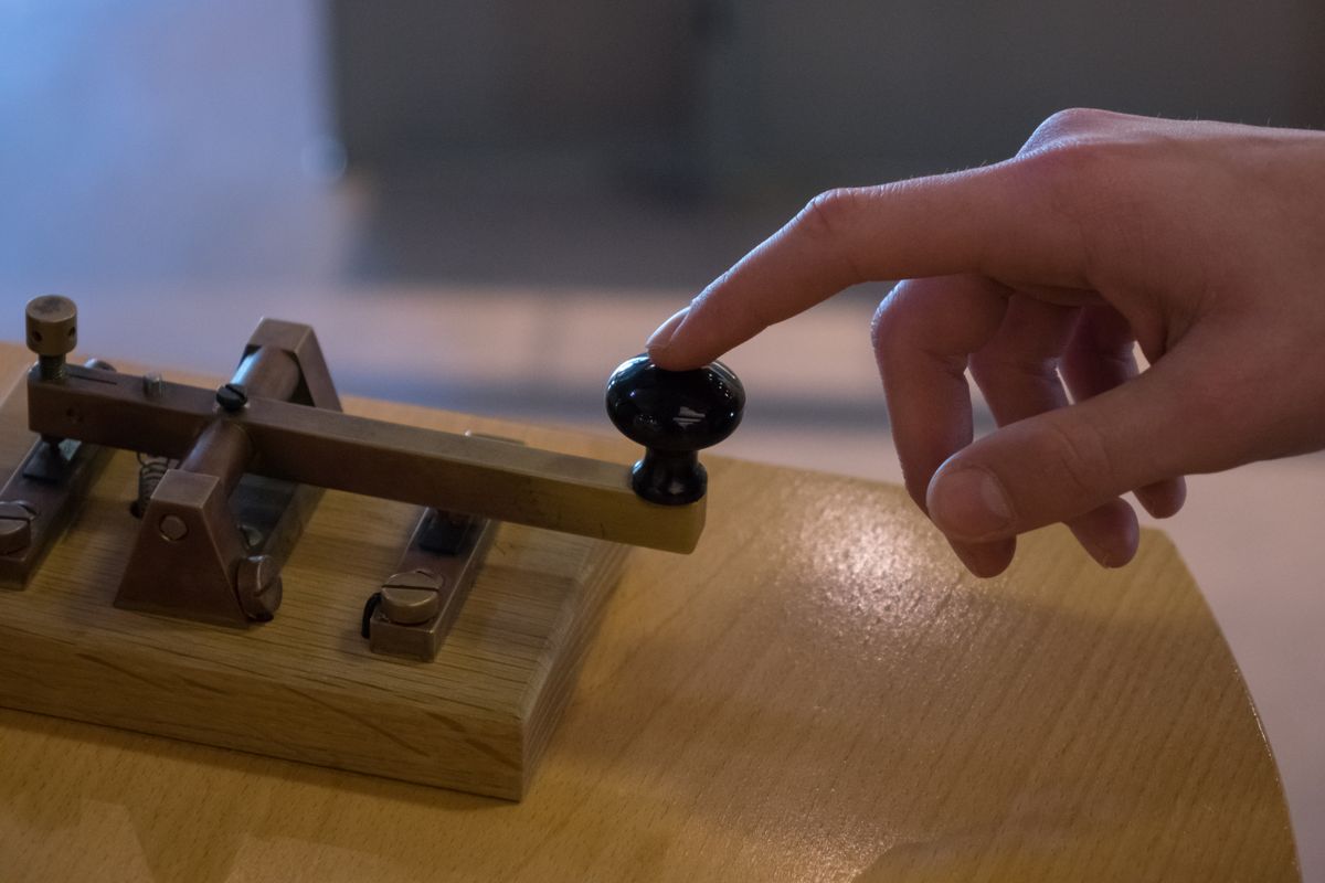 The old and vintage telegraph key and operator's hand