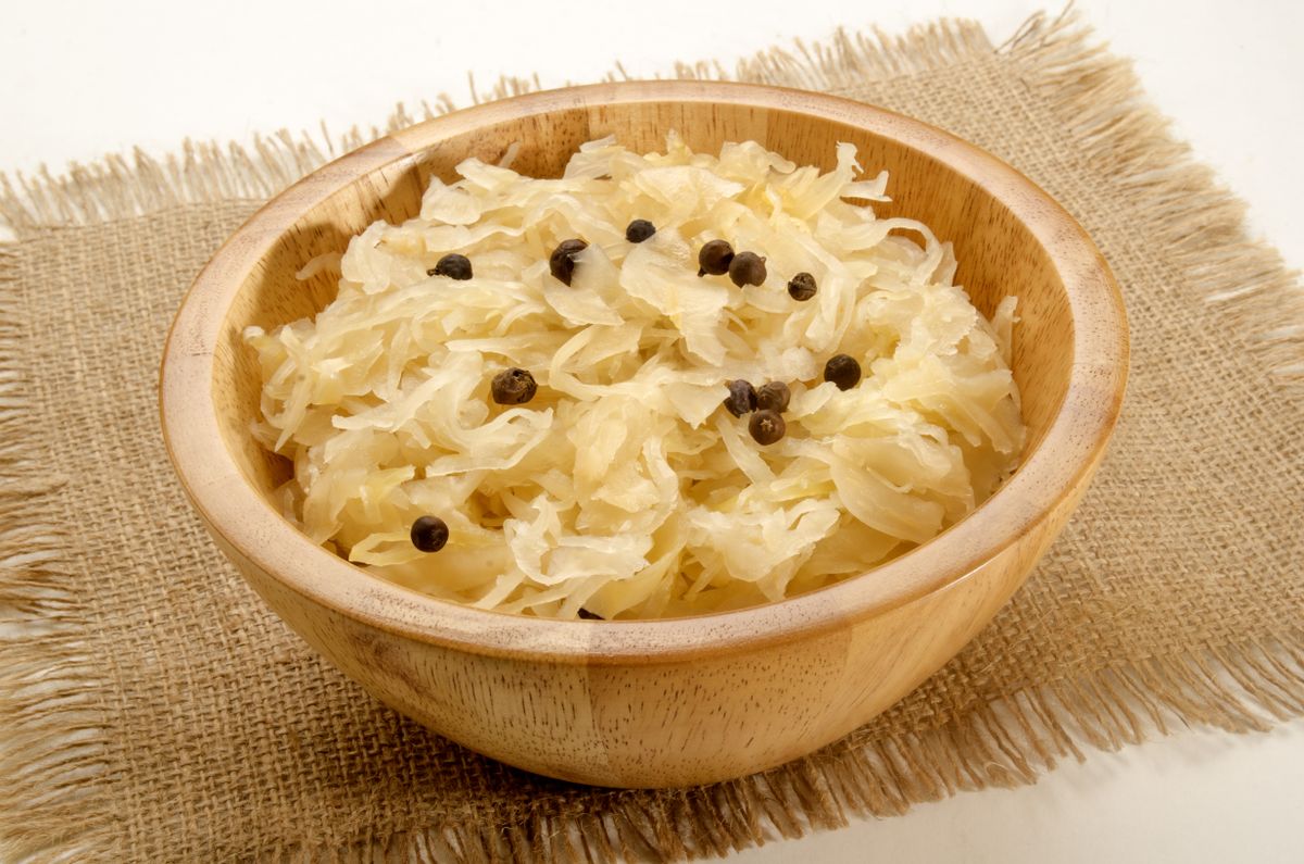 home made sauerkraut in a wooden bowl with juniper berries