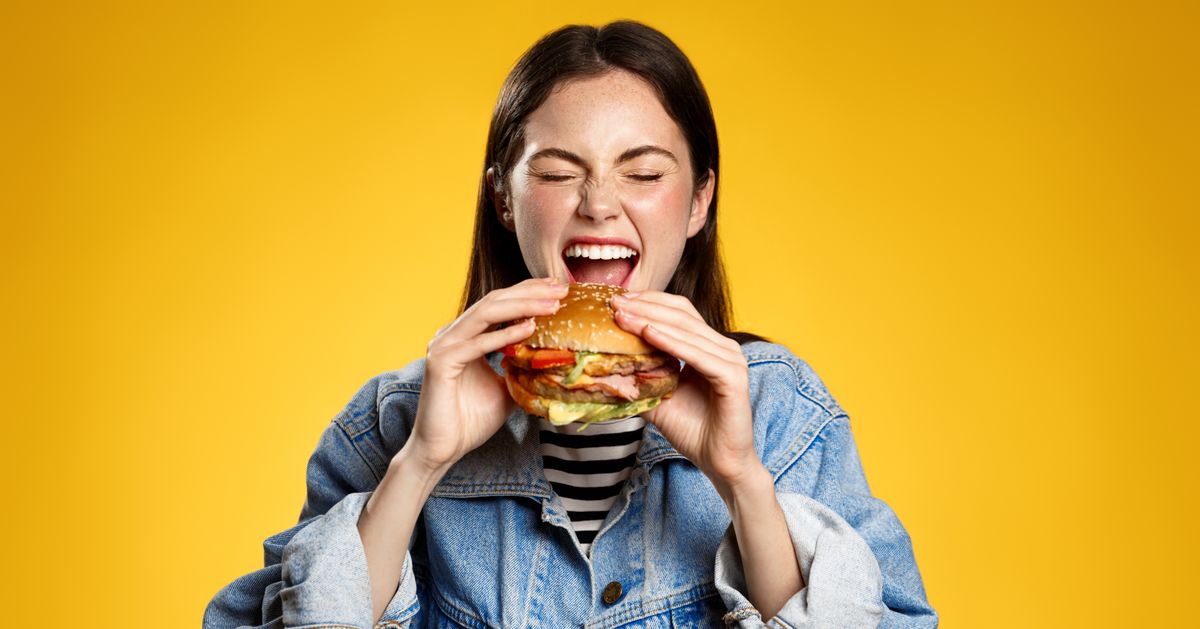 Girl,Bites,Cheeseburger,With,Pleasure.,Woman,Eating,Hambuger,,Order,Burger