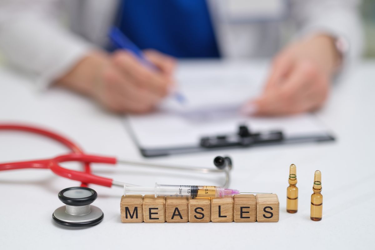 A,Doctor,Carefully,Documents,The,Measles,Vaccination,Process,,Noting,The