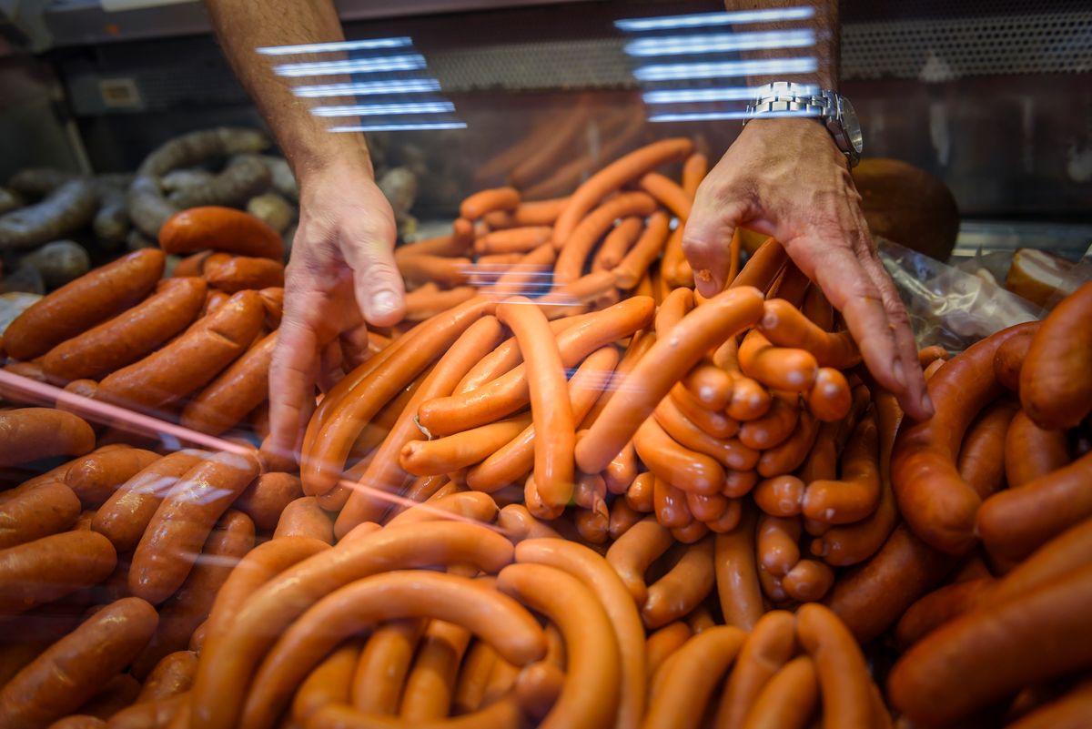 Two,Hands,Organising,Frankfurter,Sausages,In,A,Butcher,Shop's,Counter