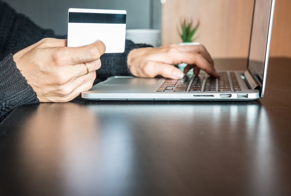 Hands,Of,Woman,Holding,Credit,Card,And,Using,Laptop,,Online