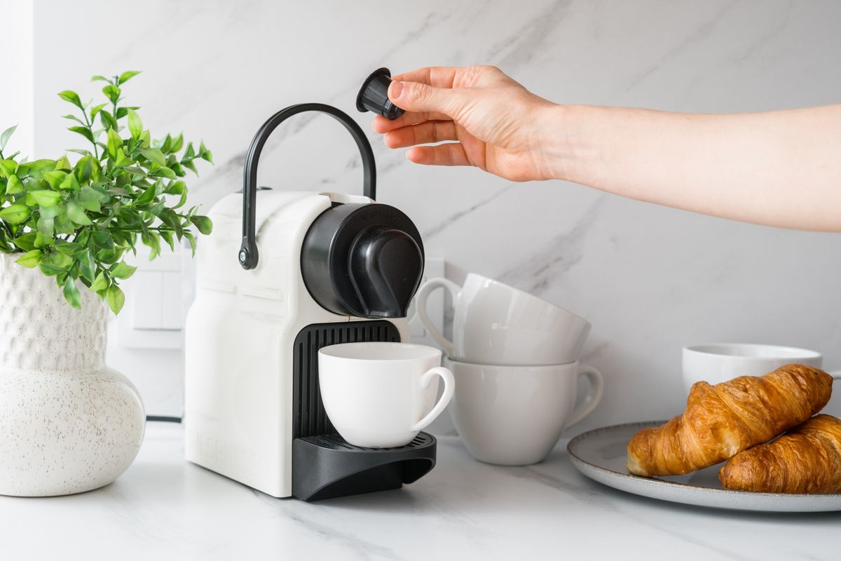 Woman,Inserts,A,Coffee,Pod,Into,Espresso,Machine.,Coffeemaker,,Cups